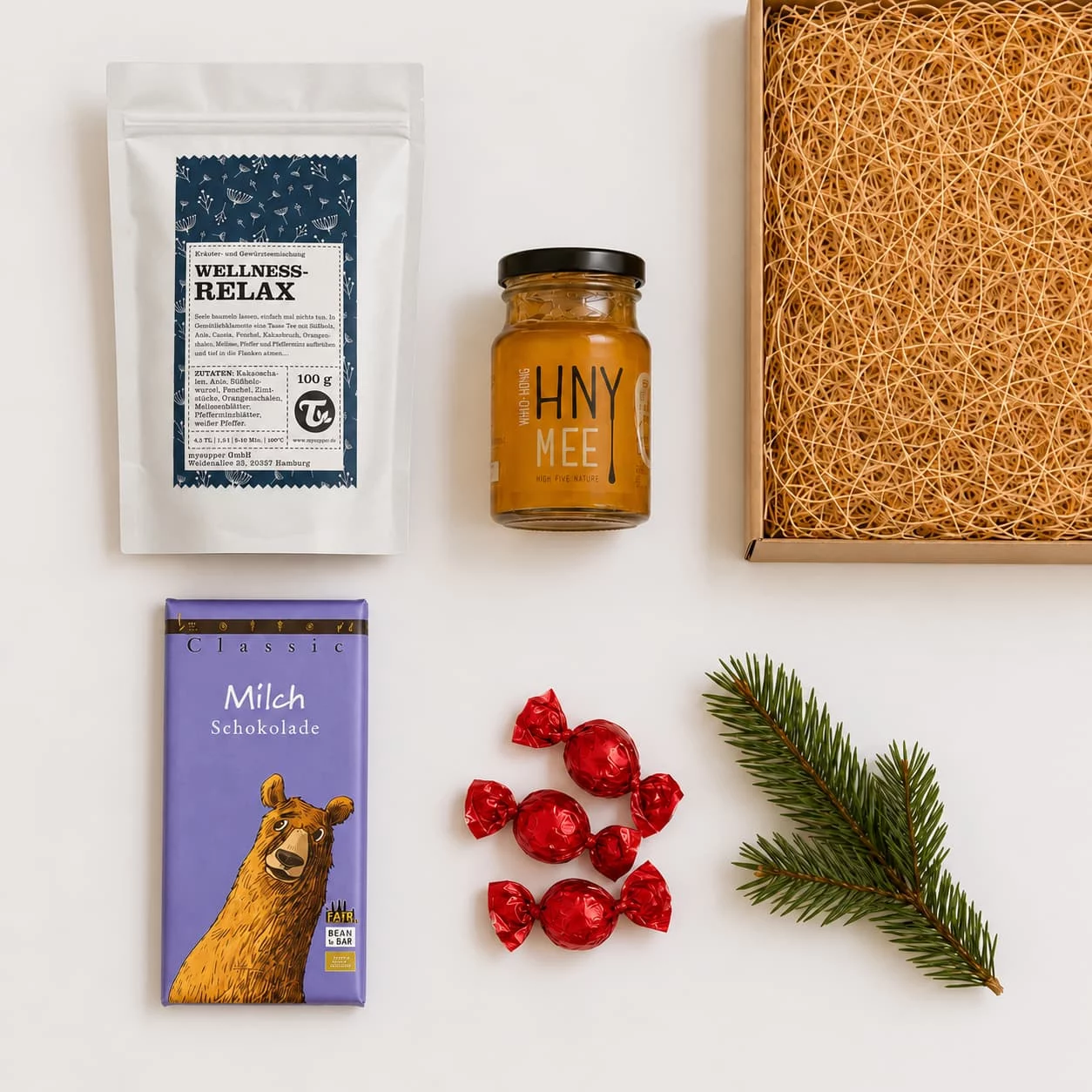 Inhalt des Tee-Geschenksets: Tee Wellness-Relax, Honig von HNYmee, Zotter Milchschokolade mit Bär und Pralinen